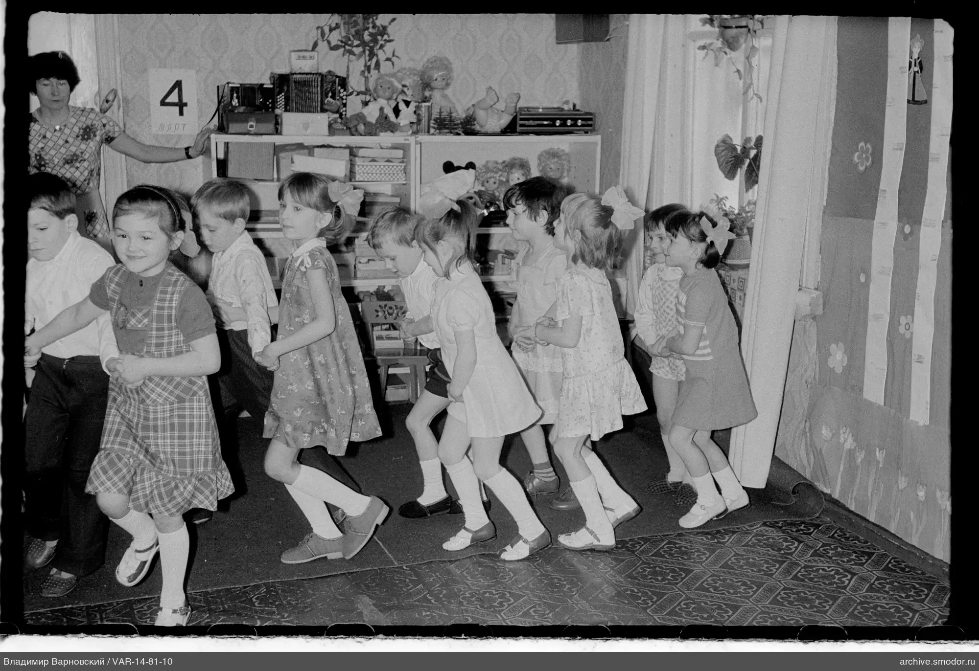 Group of children and woman indoors