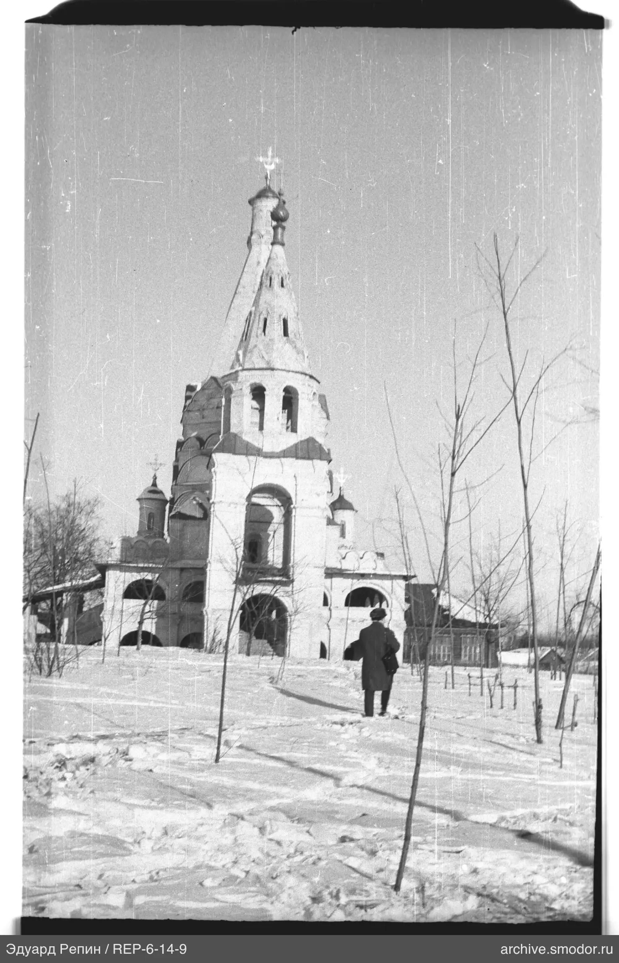 Человек на заснеженной тропинке у церкви