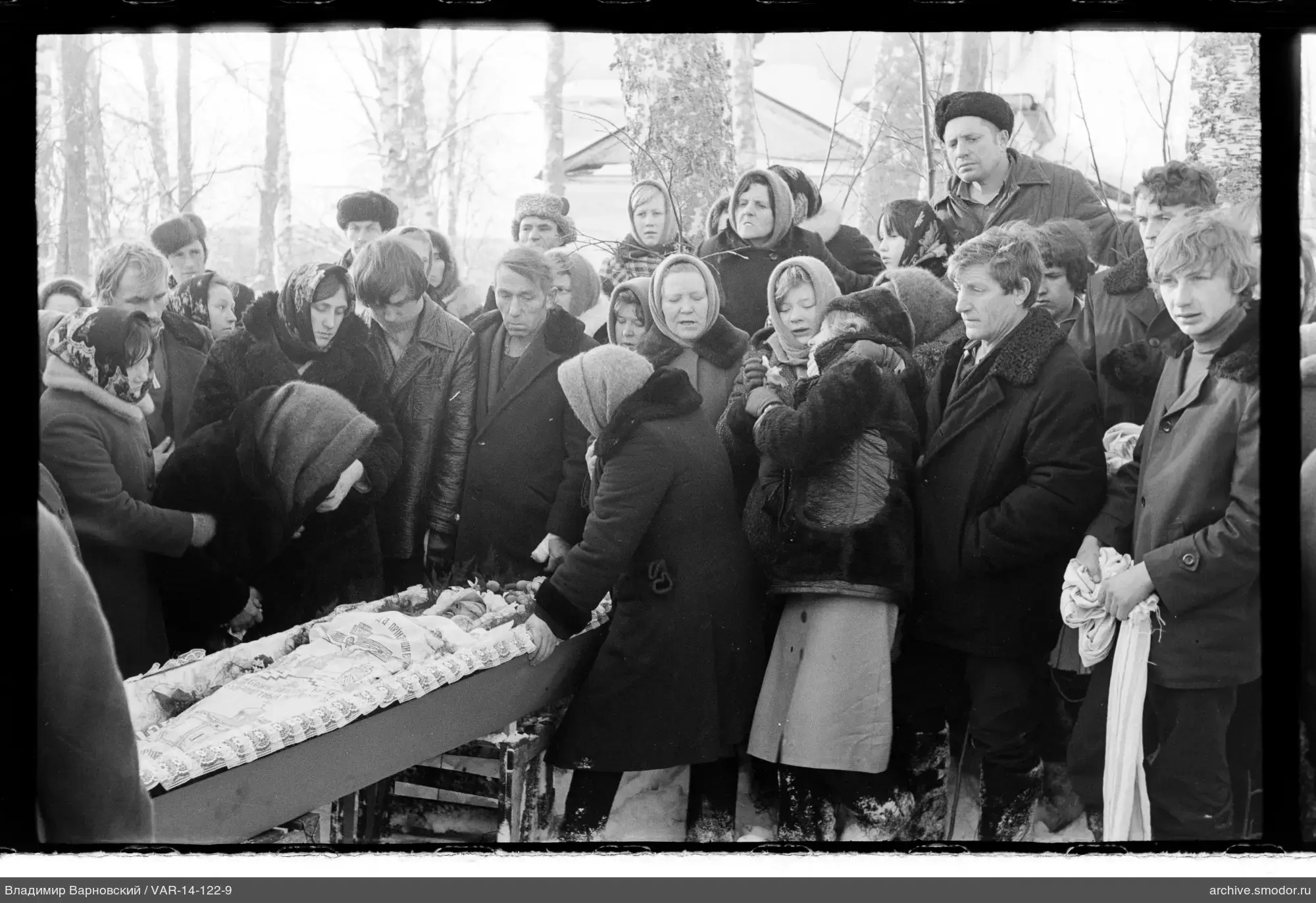 Группа людей у деревянного гроба