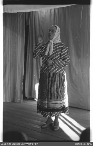 Frau in Kleid mit Muster und Schürze
