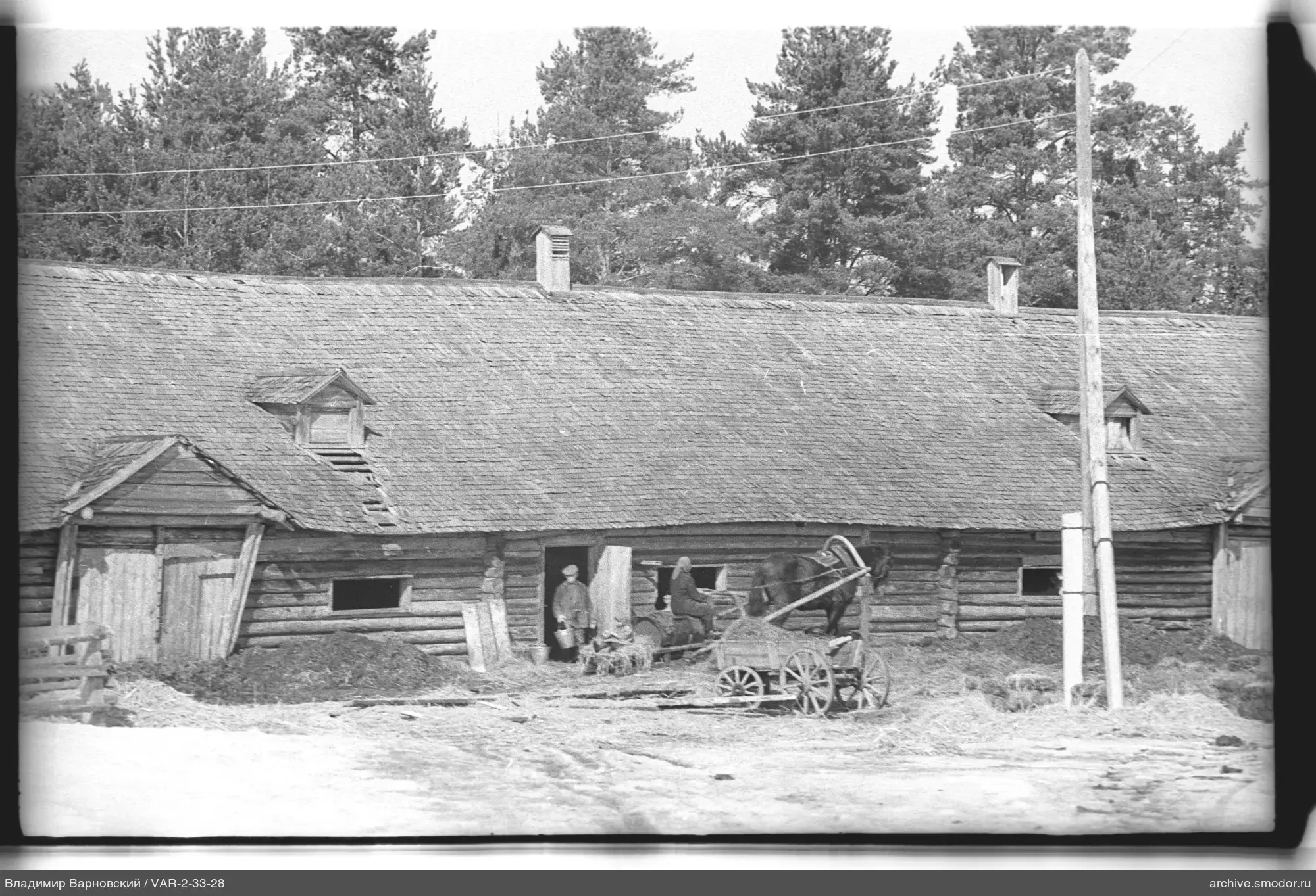Langes Holzgebäude mit Pferd und Wagen