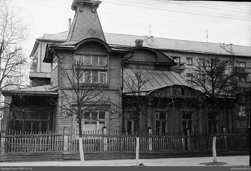 Holzhaus mit Turm und Backsteingebäude