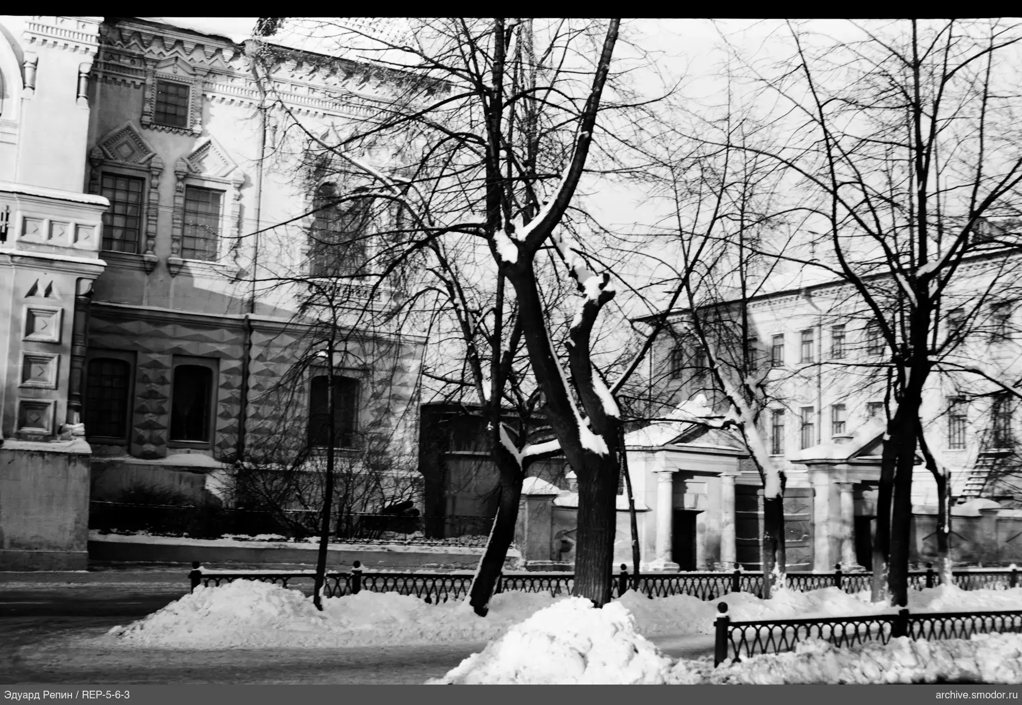 View of street with snow-covered sidewalk and buildings