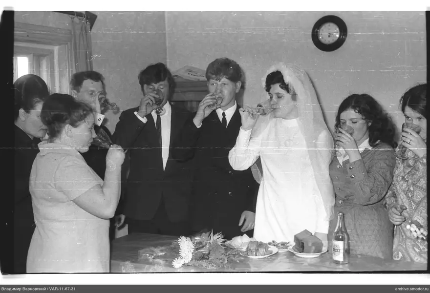 People standing by a table with flowers and dishes