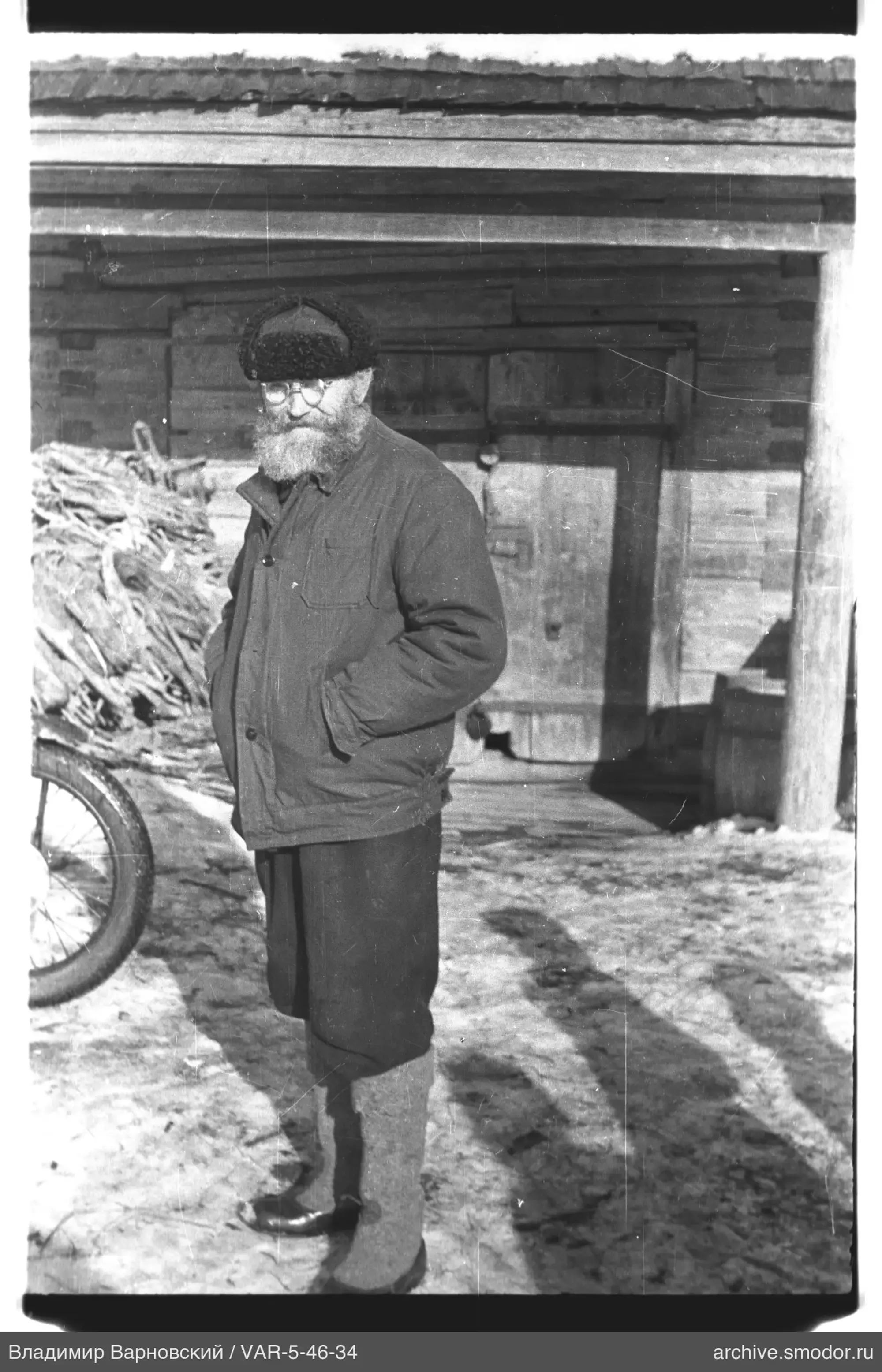 Мужчина у деревянного здания на снегу