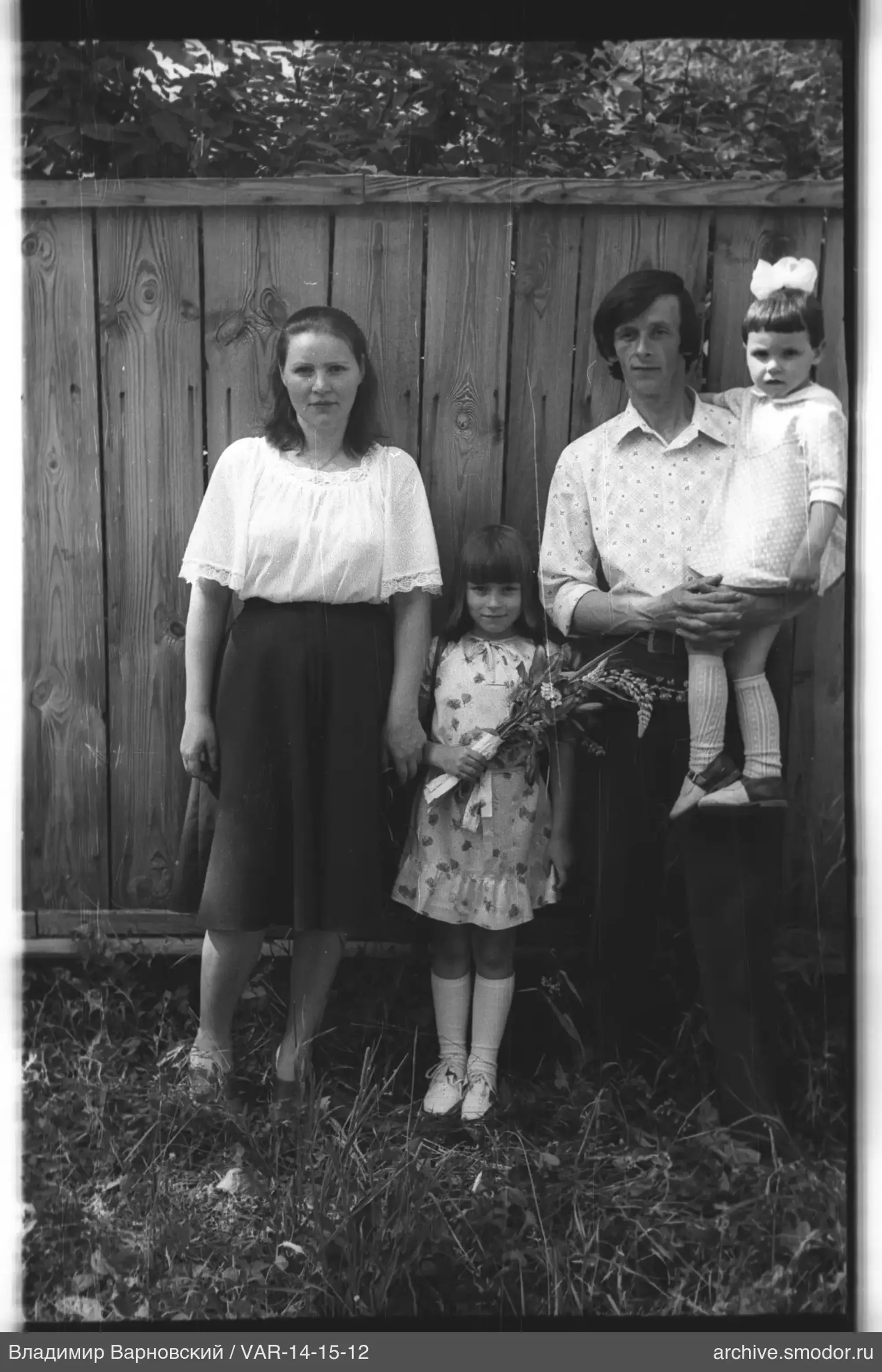 Group portrait against a wooden fence