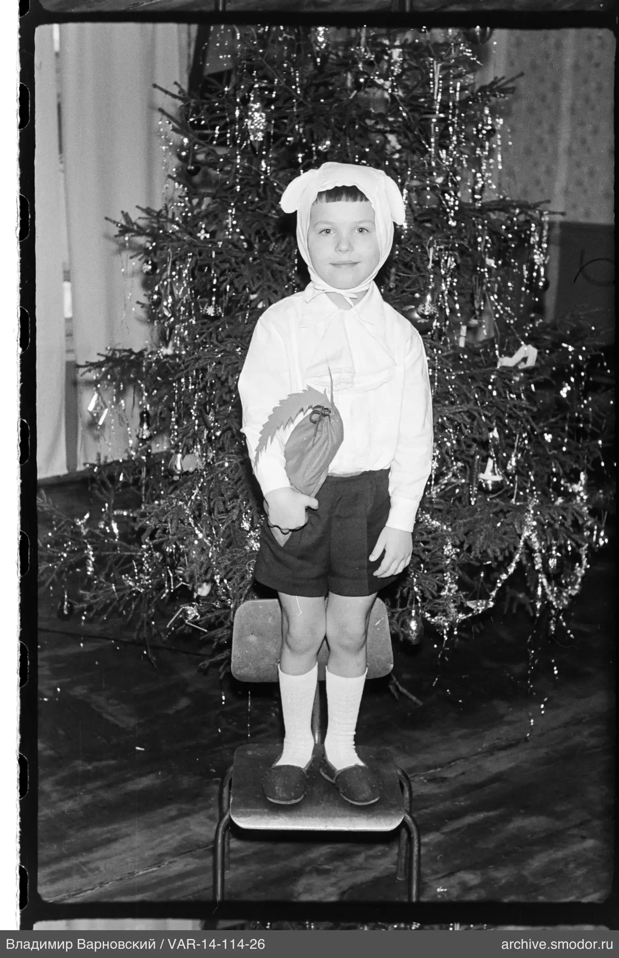 Child with toy near Christmas tree