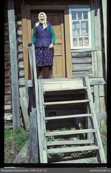 Женщина на деревянной веранде у дома