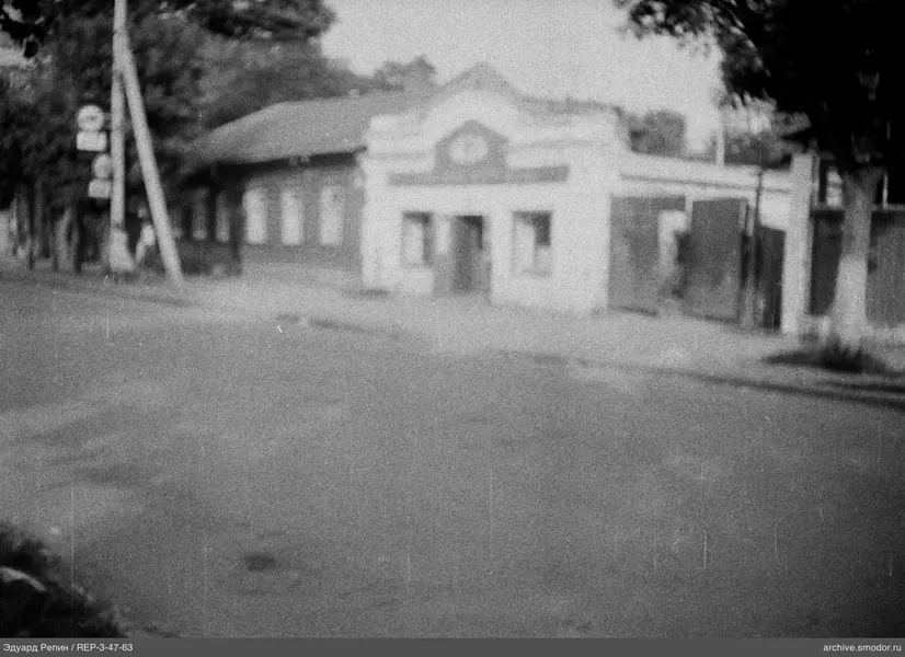 Straße mit Bäumen und Gebäude mit Dreiecksgiebel