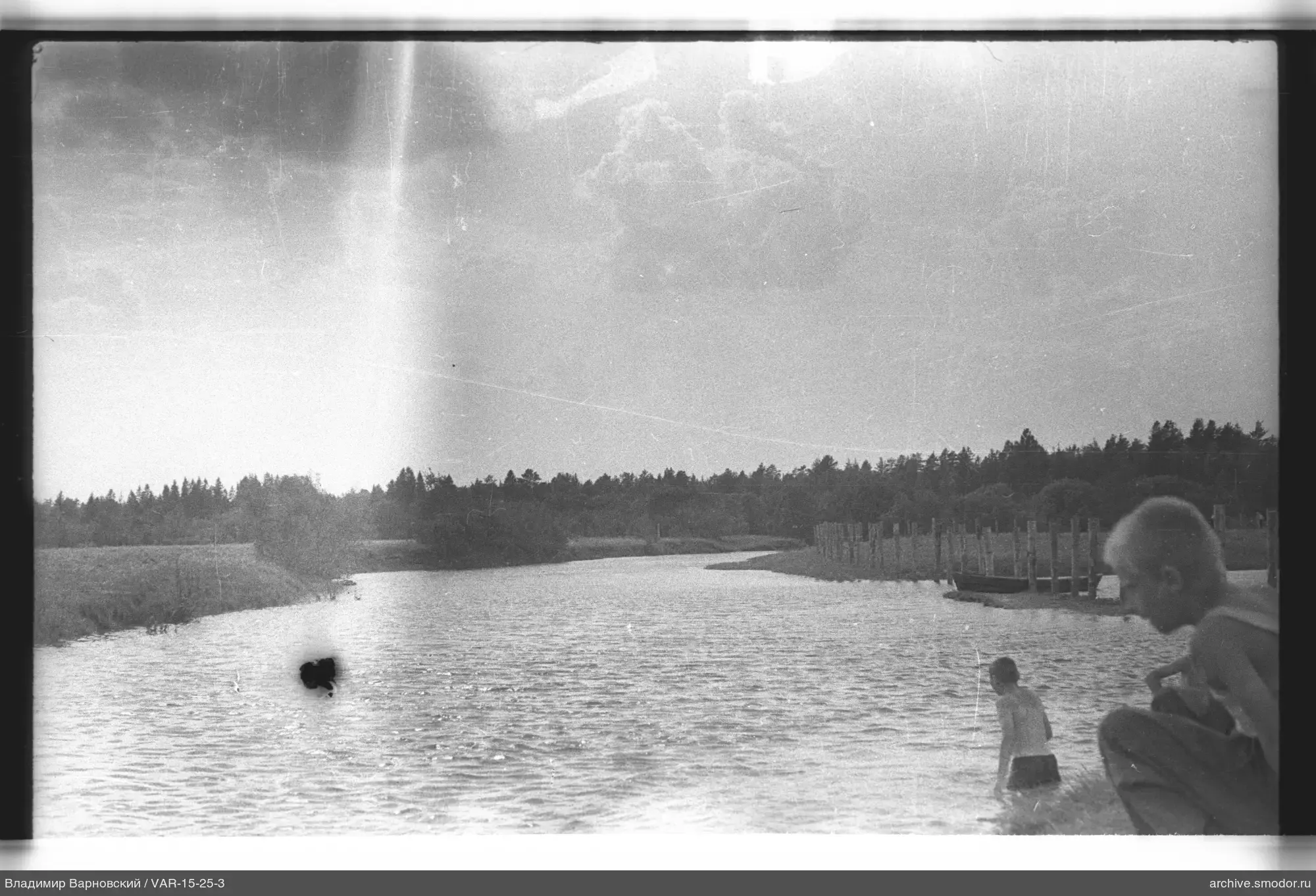 Two boys by the river with pier and boat
