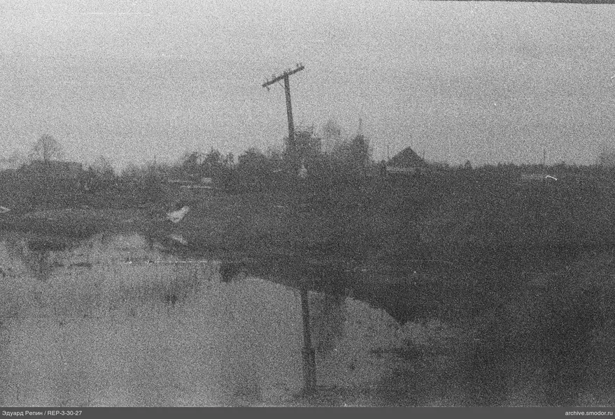 Flussufer mit Holzpfahl und Spiegelung