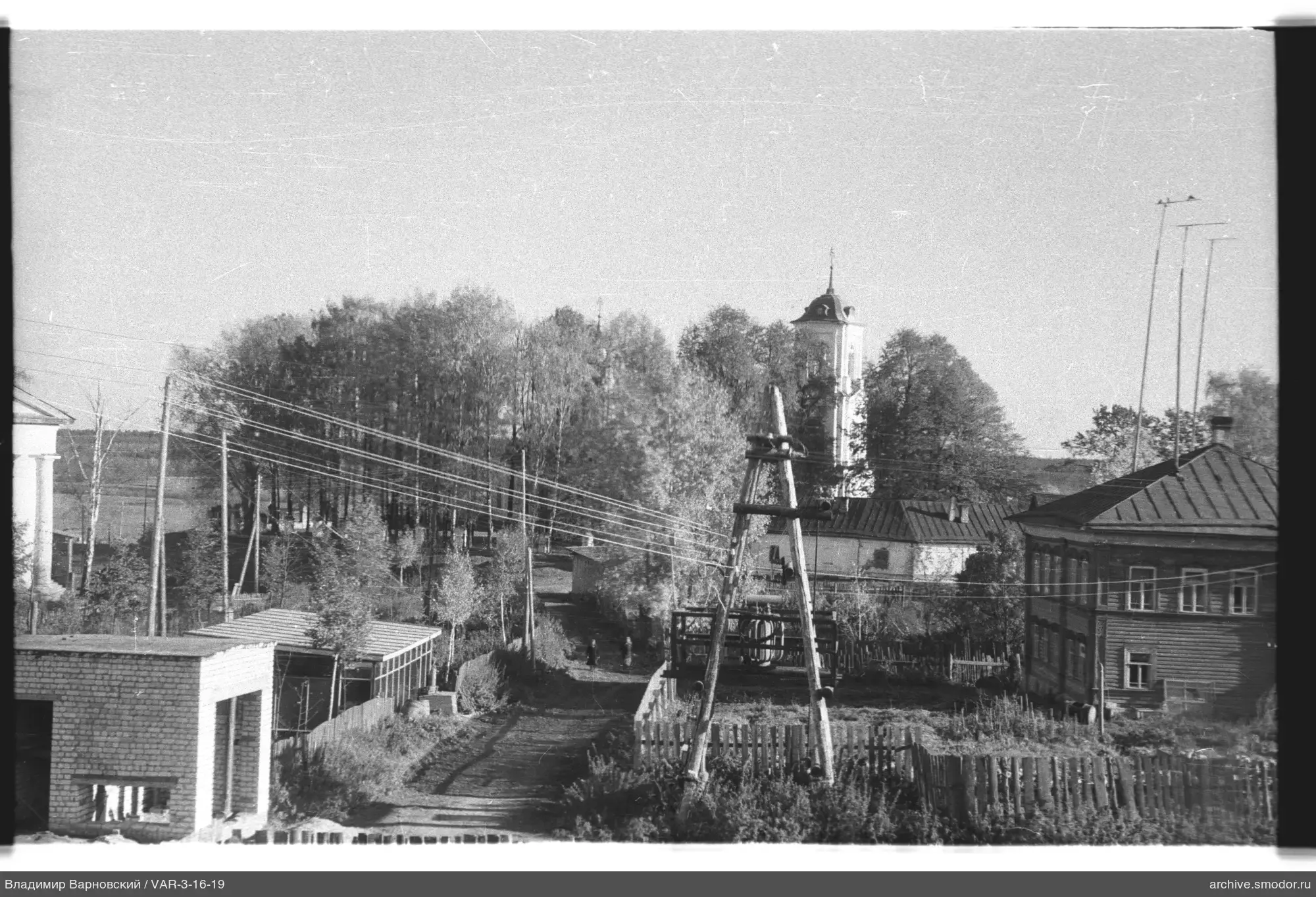 Ländliche Straße mit Kirchturm und Holzbauten