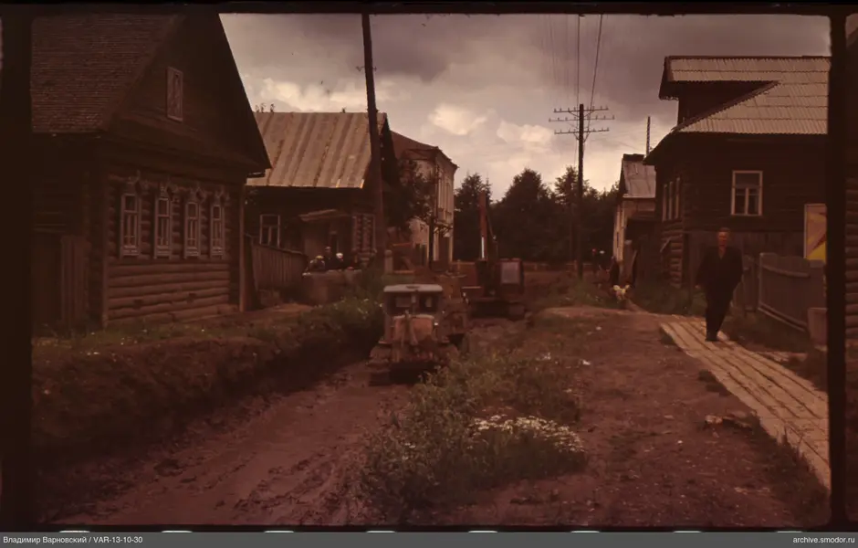 Street with wooden houses and construction vehicles