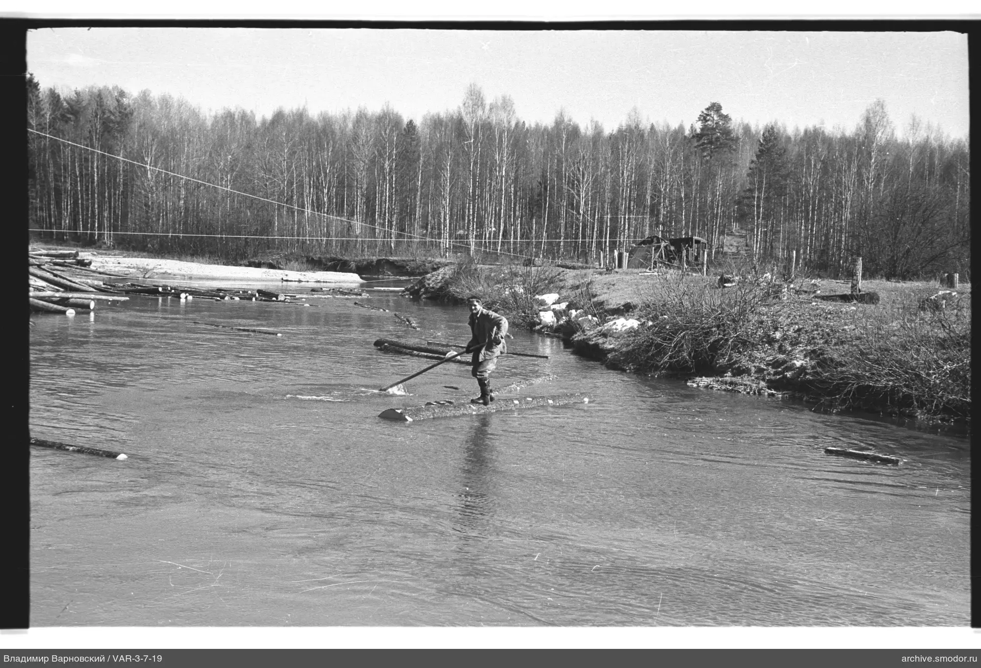 Mann mit Stange im Fluss