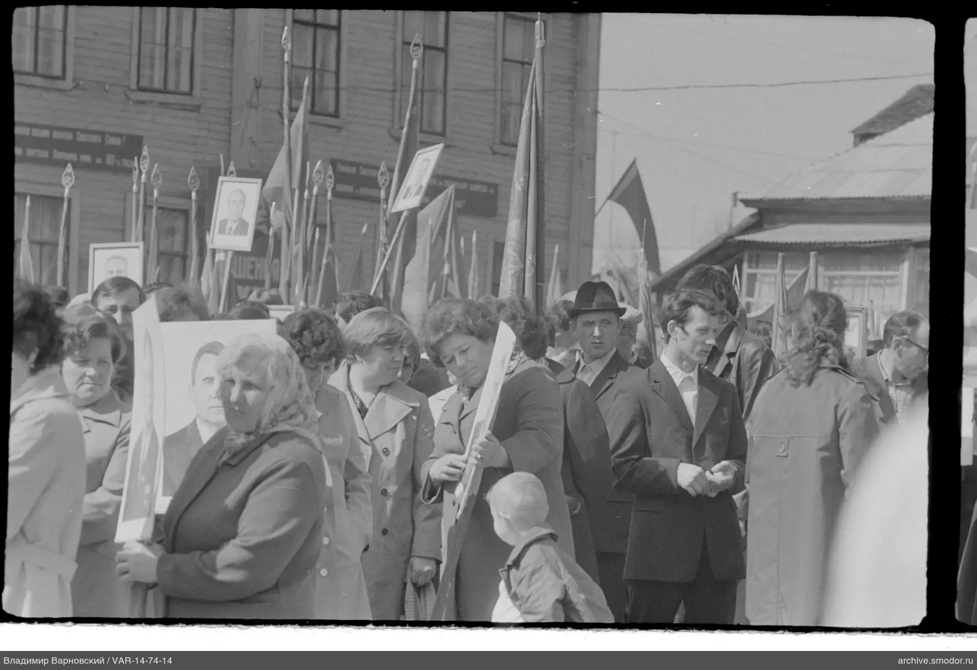 Gruppe von Menschen mit Porträts und Flaggen auf der Straße