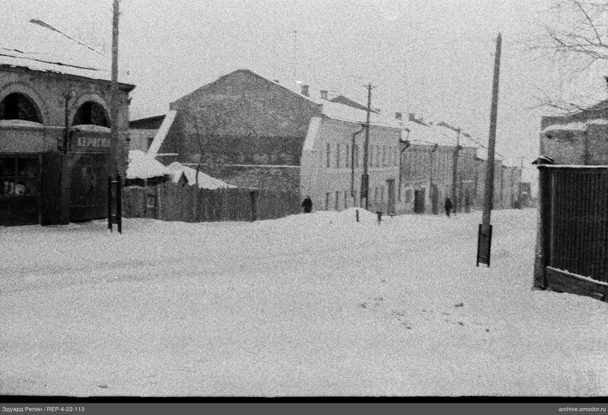 Заснеженная улица с домами и людьми