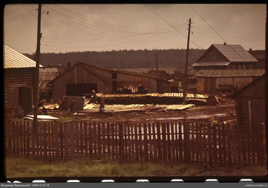 Child on wooden platform near utility buildings