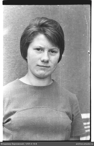 Portrait of a woman against a plain wall