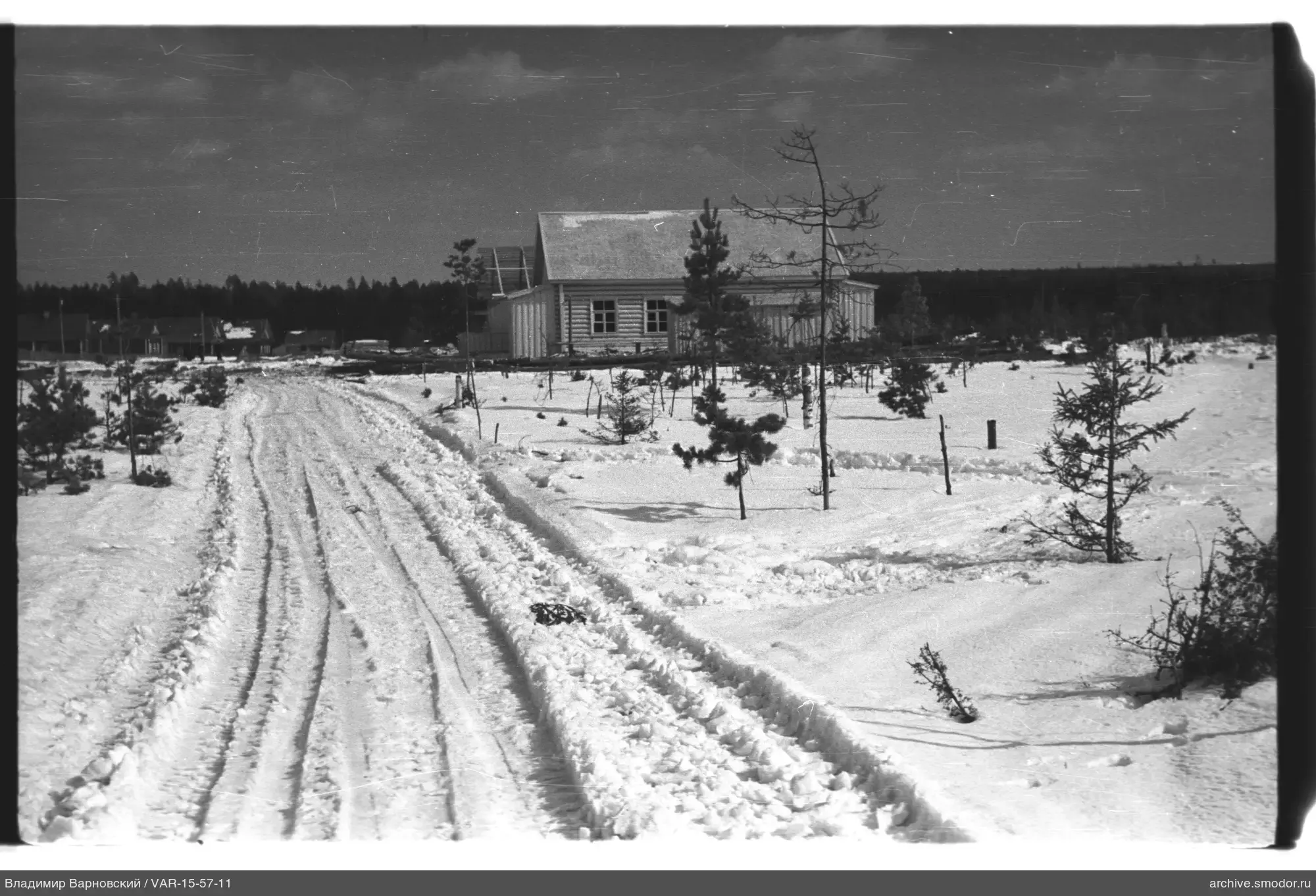 Schneebedeckte Straße zum Holzhaus