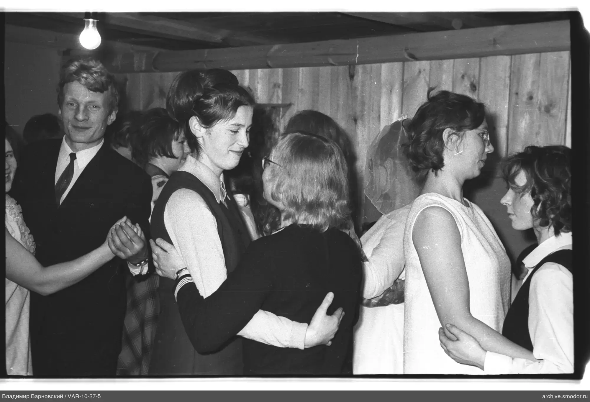Dancing couples in a wooden-walled room