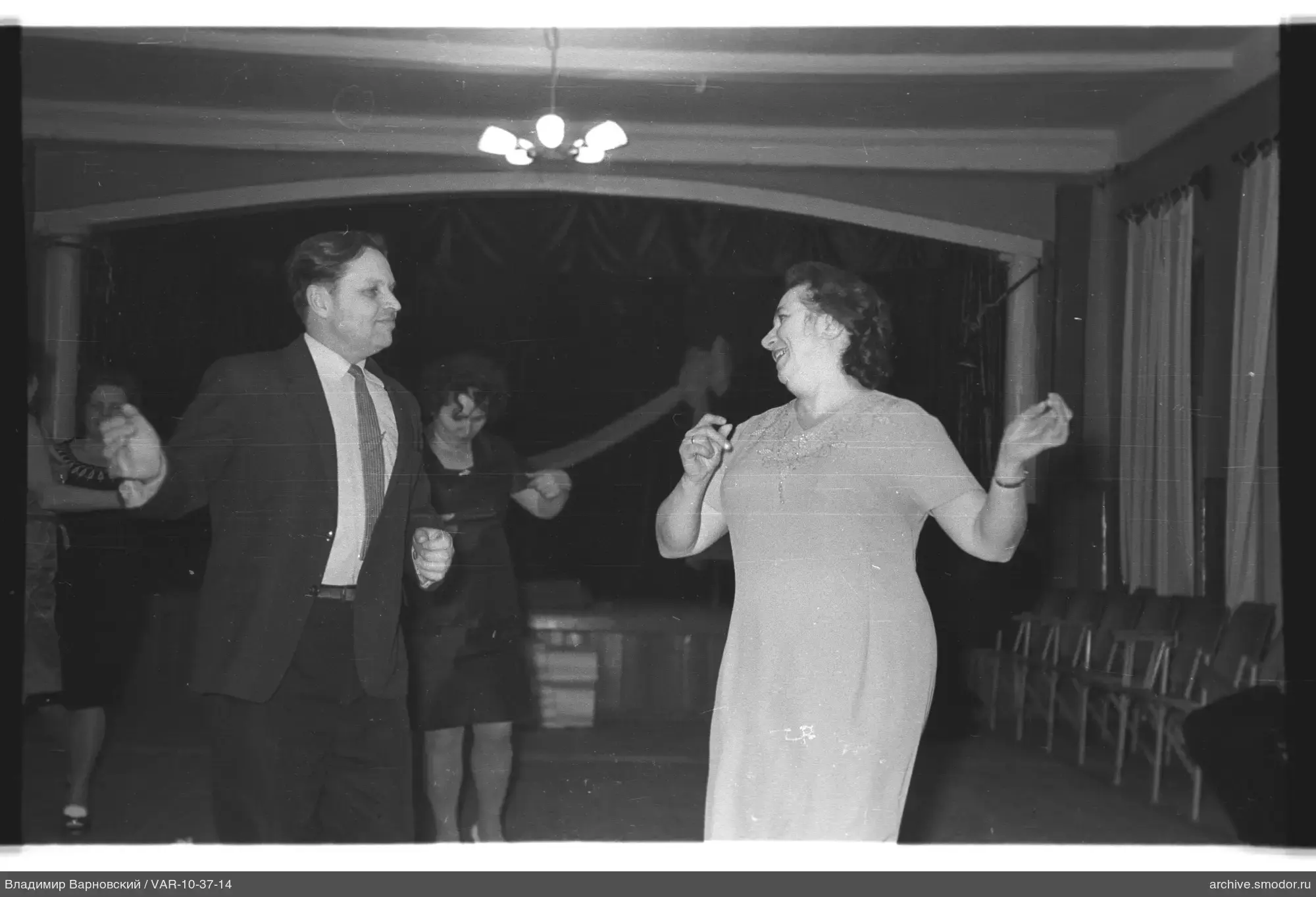 Dancing couple and spectators in a room