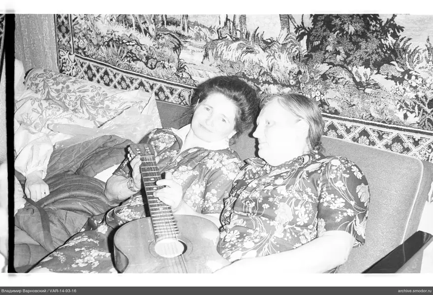 Two women with a guitar in an interior