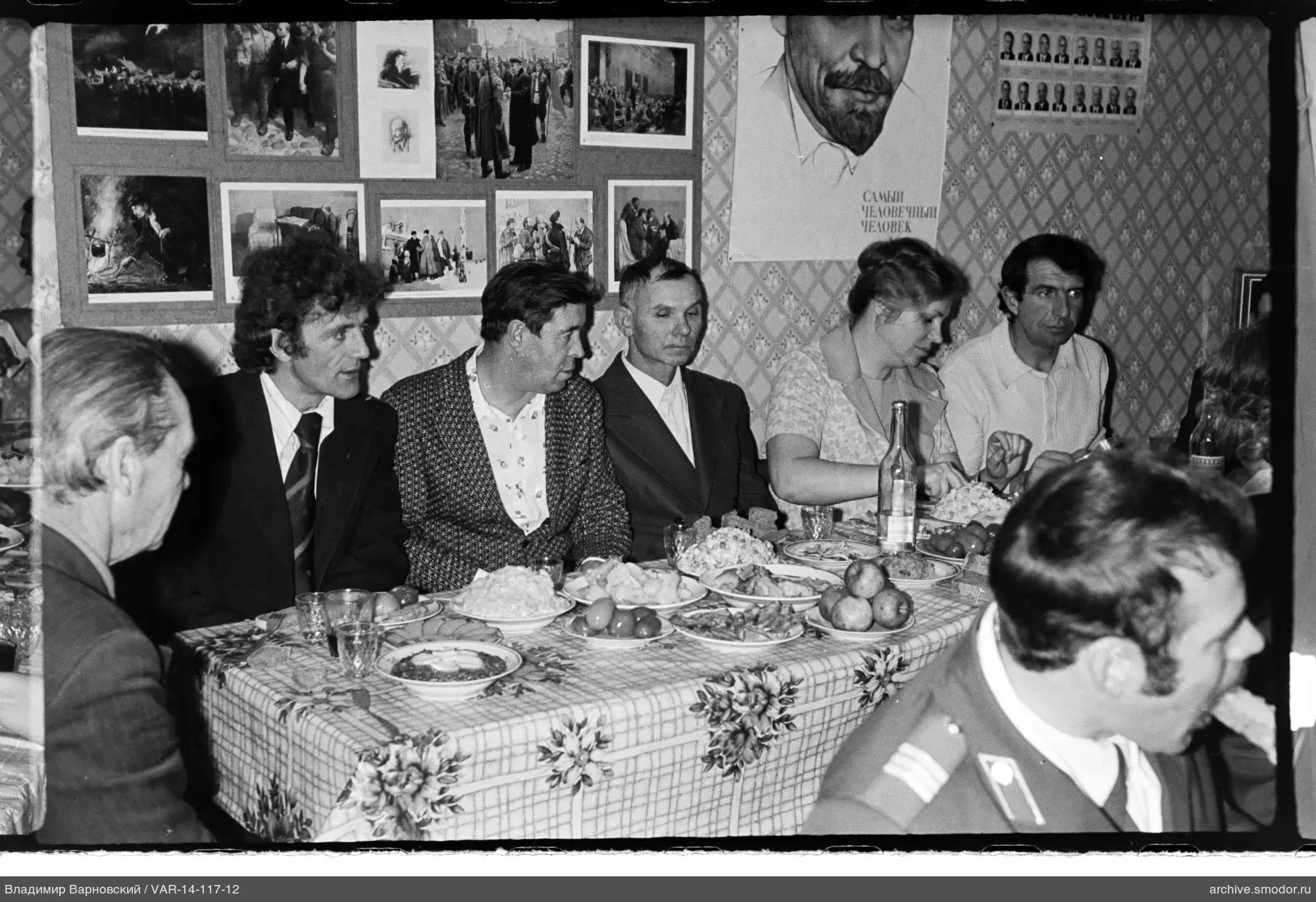 Группа за столом с фотографиями и плакатом