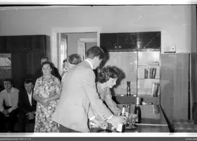 People leaning over a table at an event