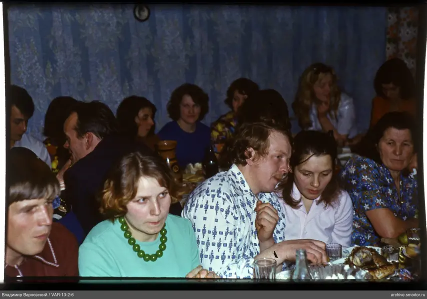 Group of people sitting at a table with dishes and bottles