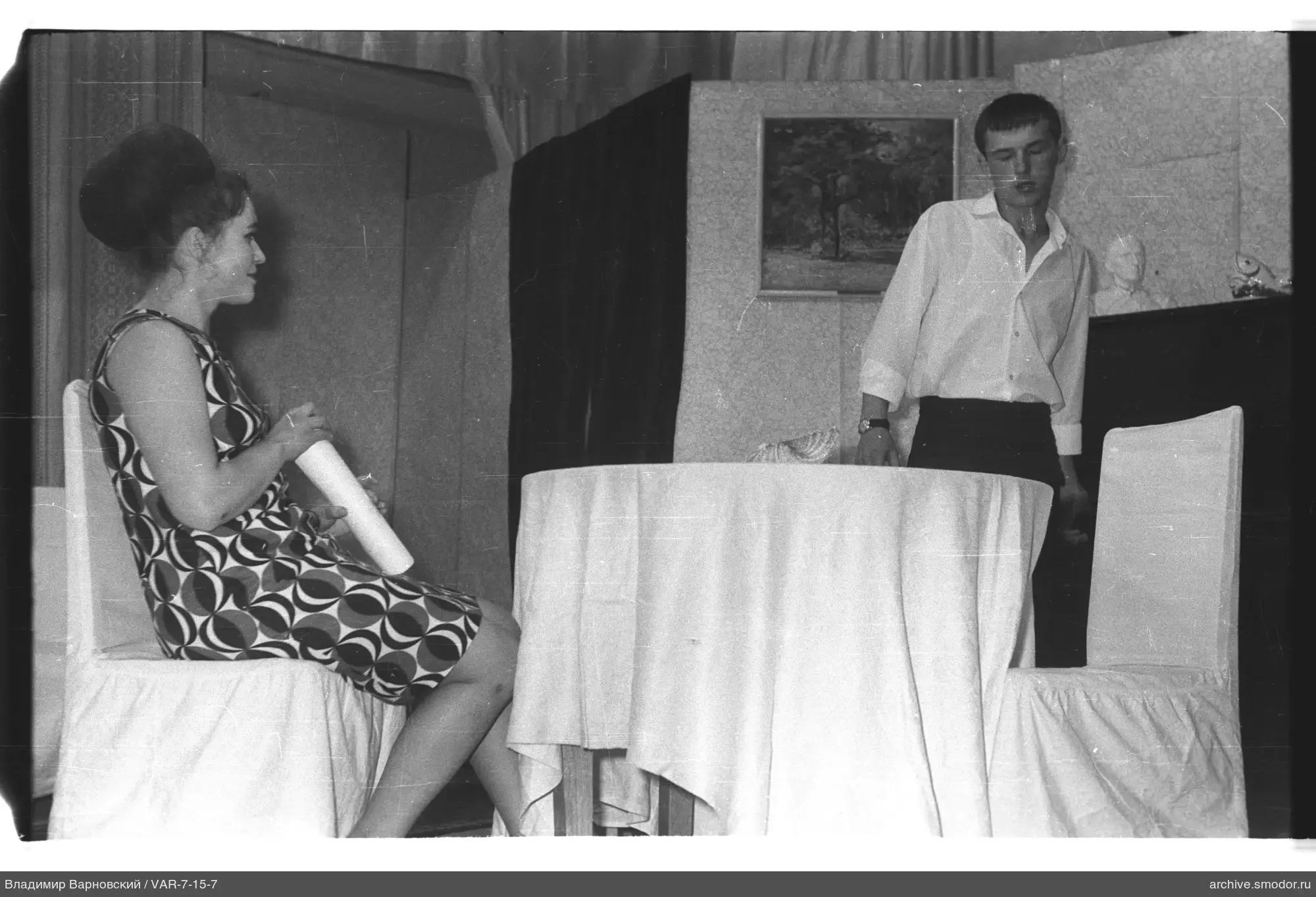Frau mit Papier und Mann am Tisch