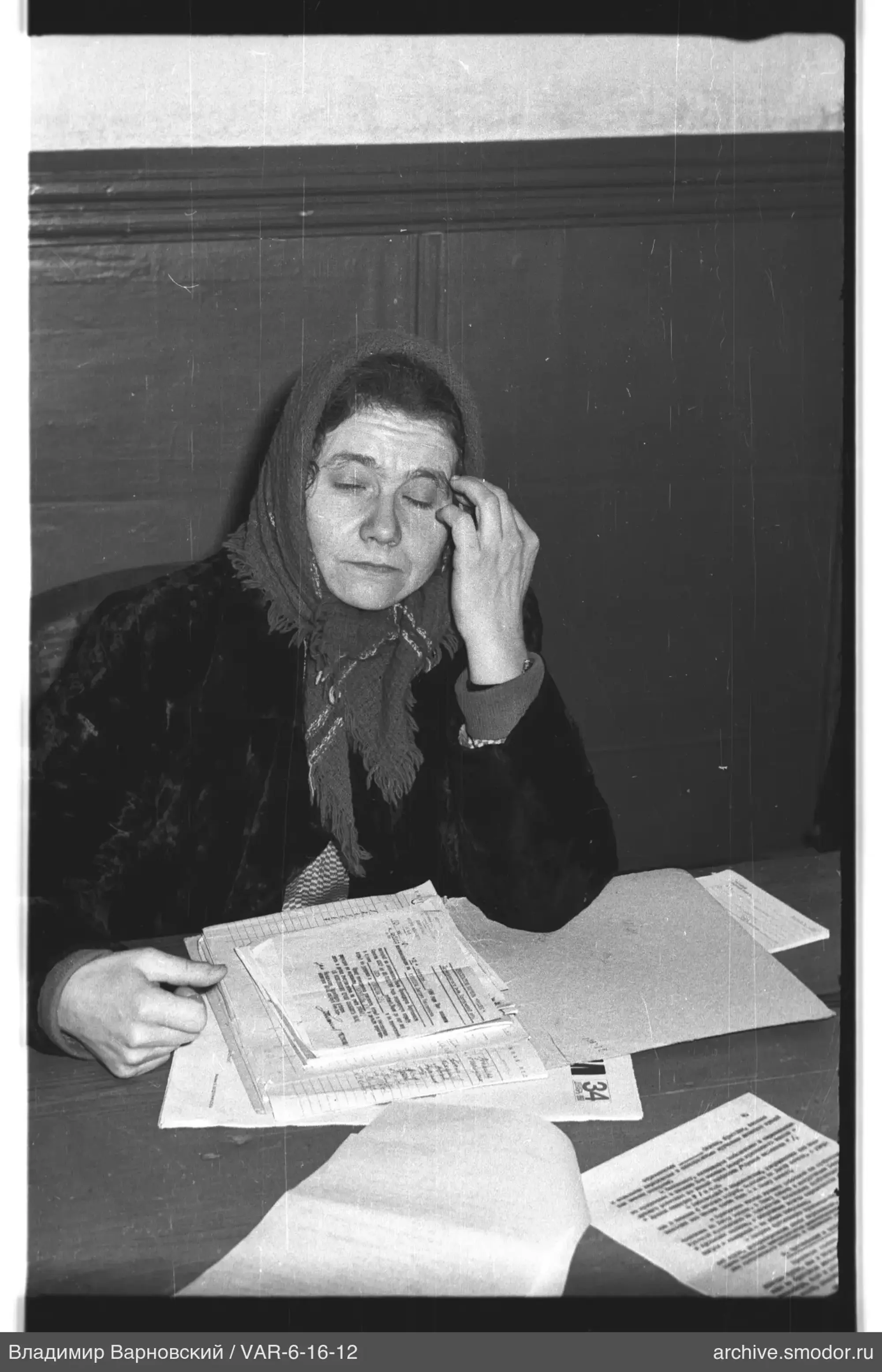 Woman with papers at wooden wall