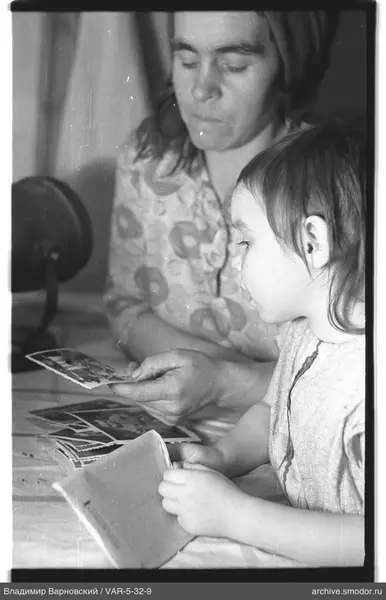 Woman and child with photographs and postcard