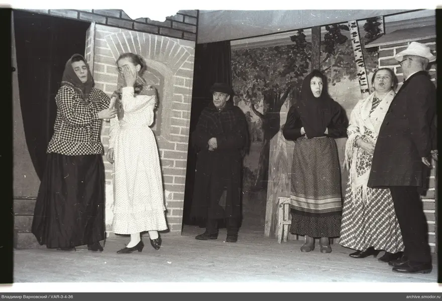 Group on stage with brick wall and tree