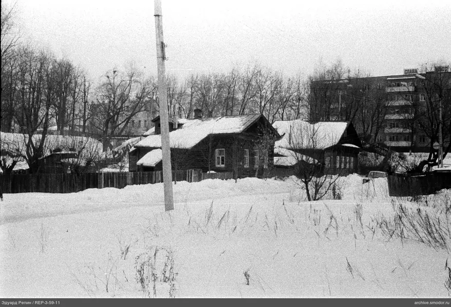 Schneebedecktes Feld und Holzhaus