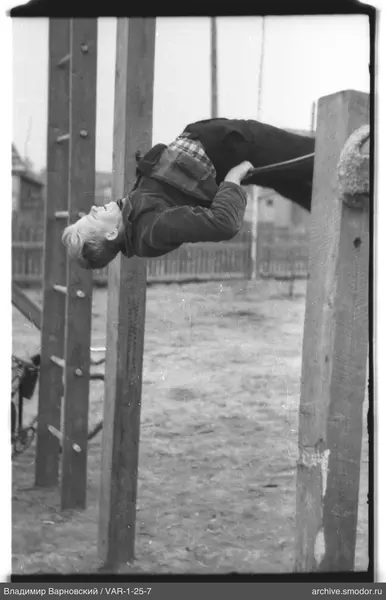 Junge an einer Reckstange auf einem Spielplatz