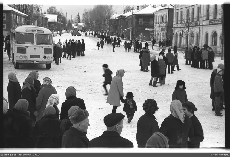 Verschneite Straße mit Bus und Menschenmengen