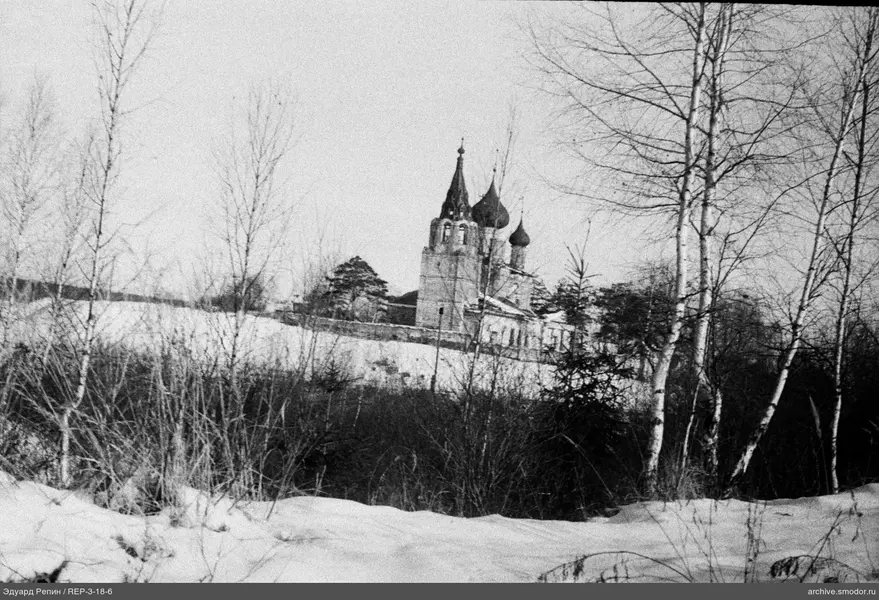 Schneebedeckter Hang und Kirche mit Zwiebeltürmen