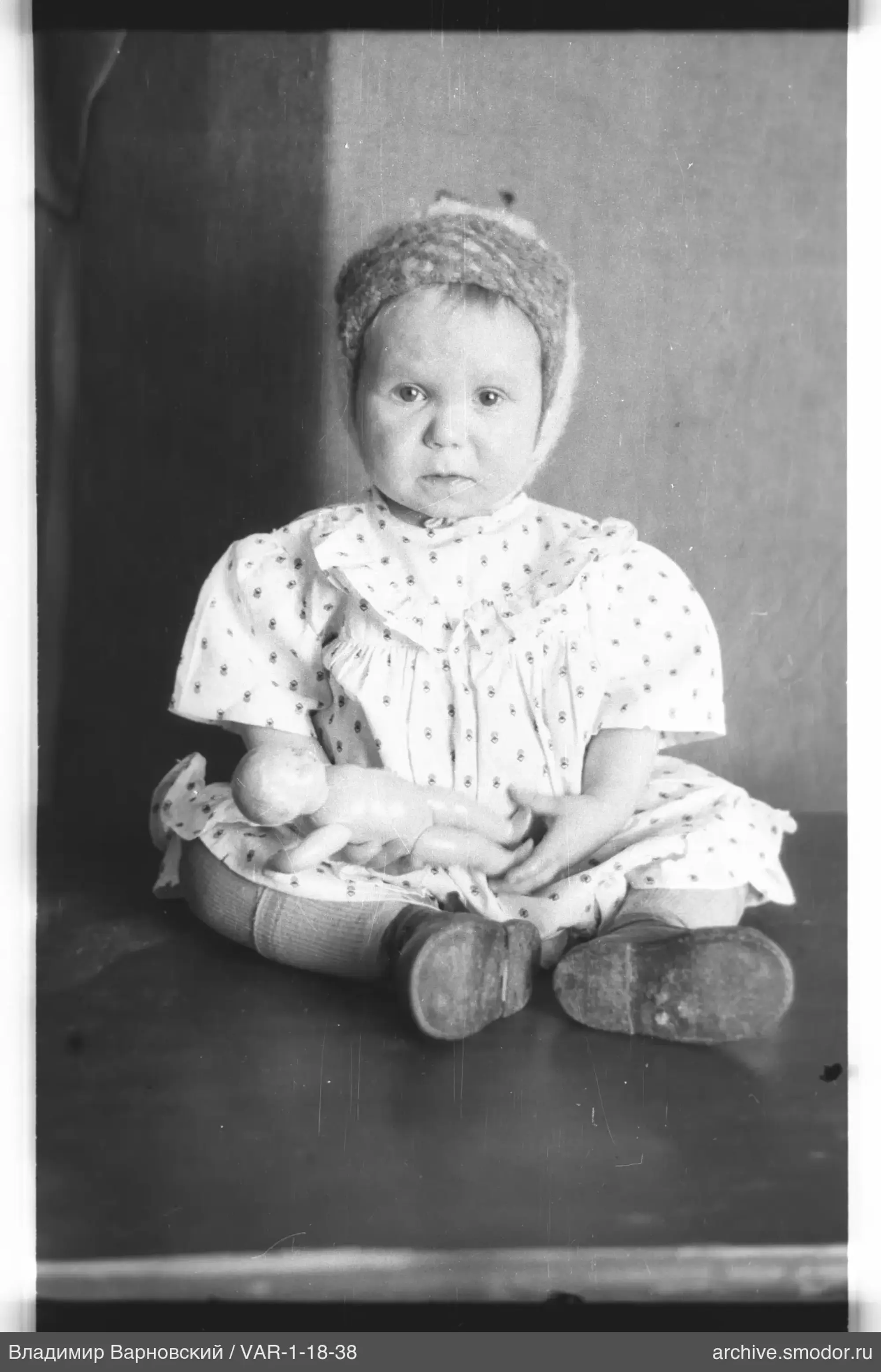 Child in a light dress and fur hat
