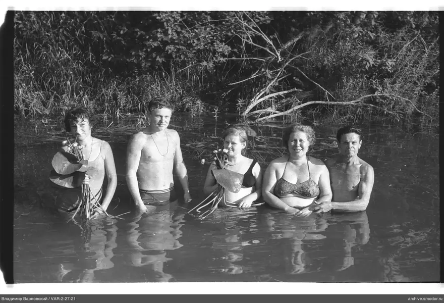 Gruppe im Wasser mit Blumensträußen