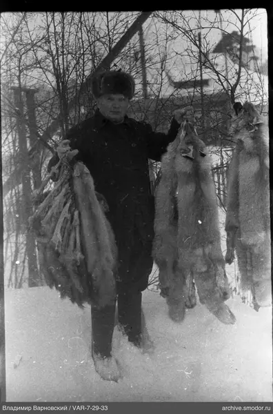 Mann mit Tierfellen im Schnee