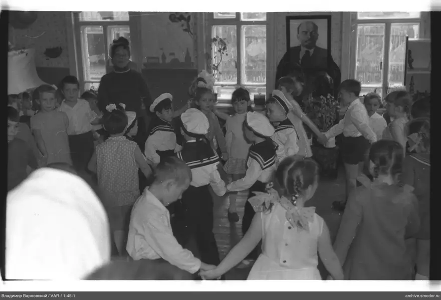 Kinder im Kreis mit Frau und Porträt