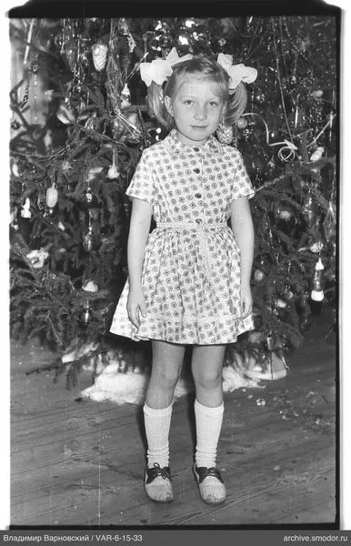 Mädchen vor geschmücktem Weihnachtsbaum