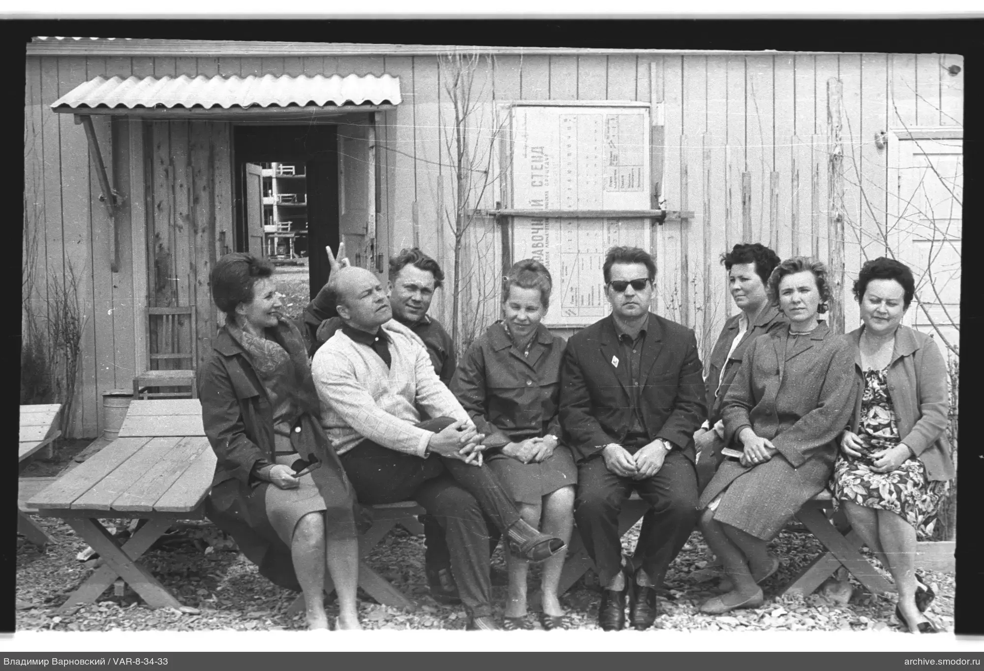 Gruppe von Menschen vor einem Holzgebäude