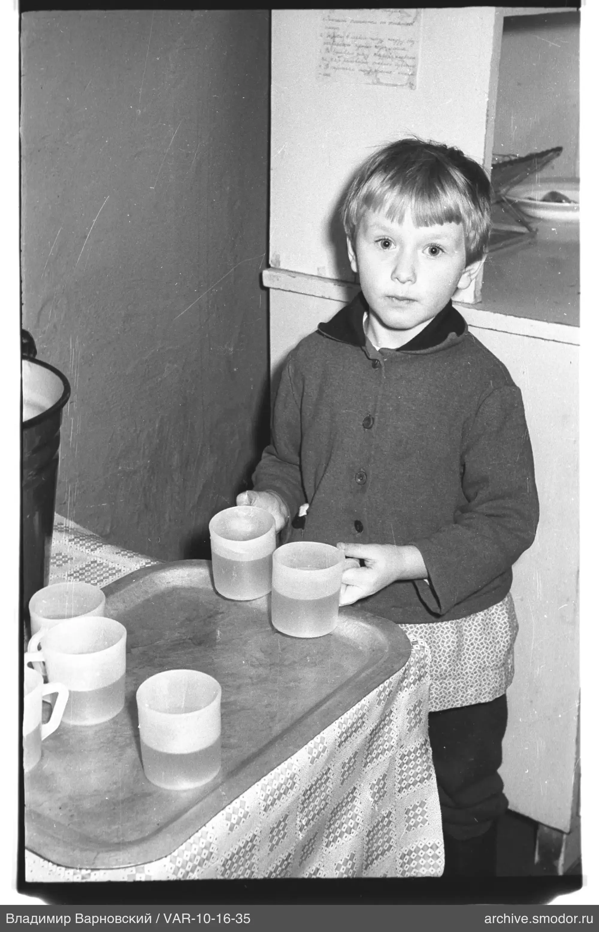 Kind mit Plastikbechern am Tisch