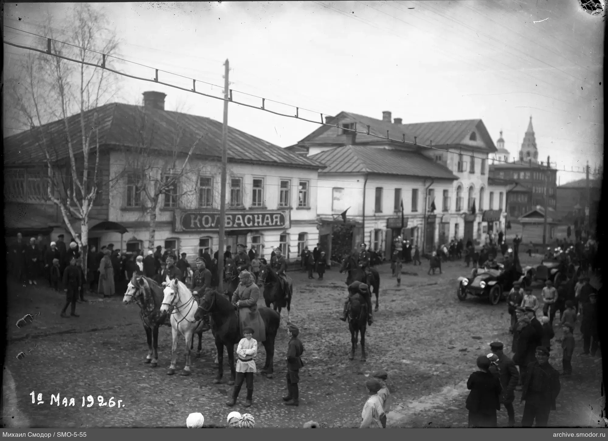 Люди и всадники на улице с автомобилем