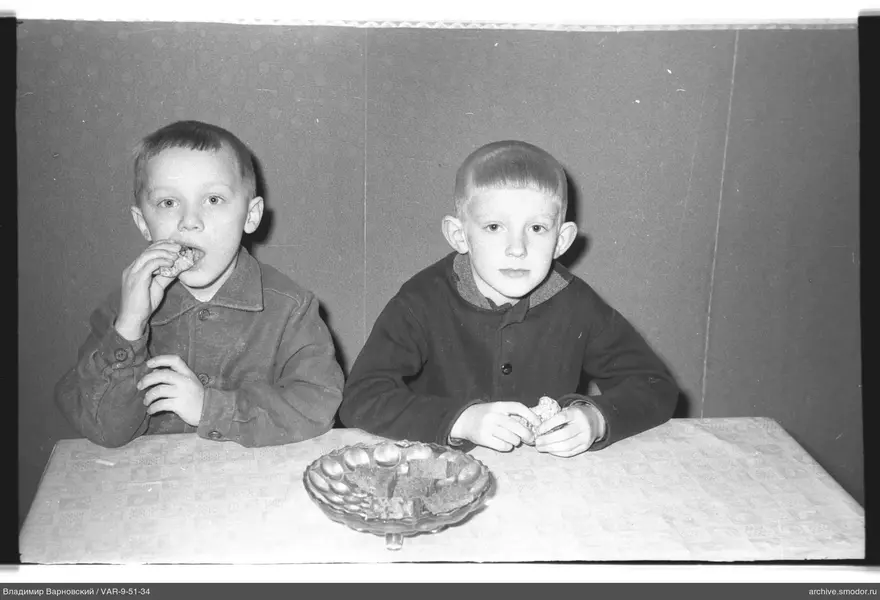 Two boys with bread at the table