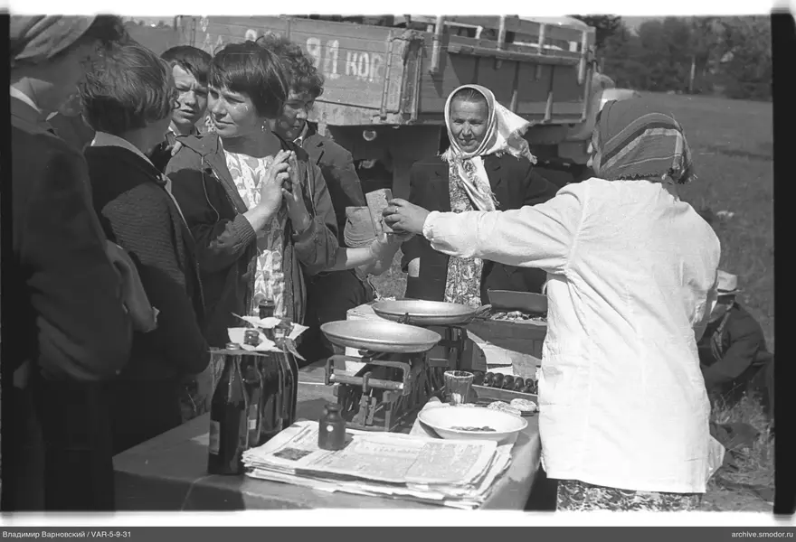Women and teenagers at a table with scales and newspapers