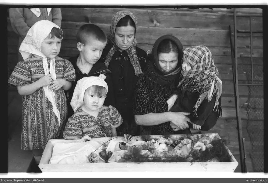 Gruppenporträt von Kindern und Frauen an einer Holzwand
