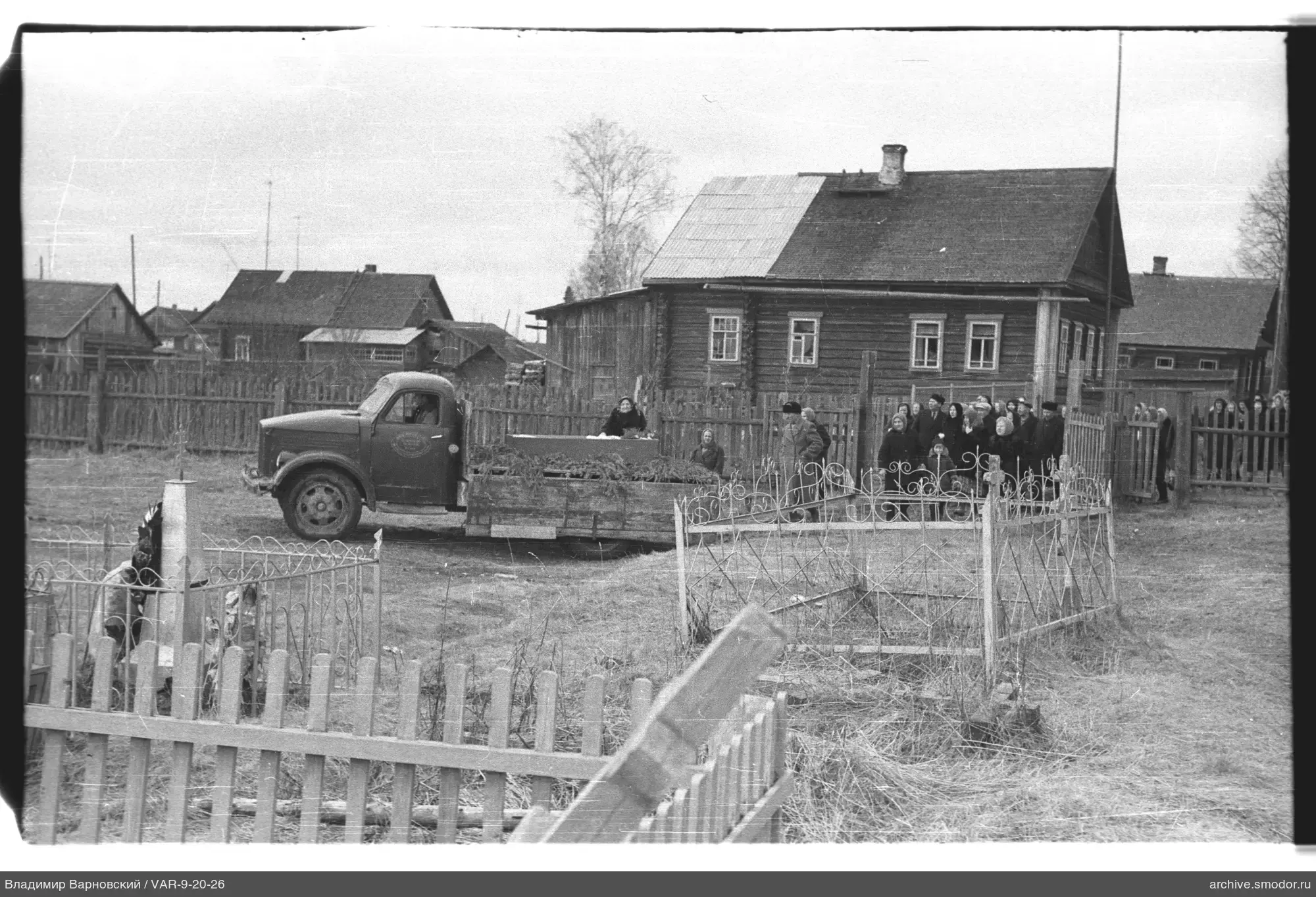 Gruppe vor Holzhaus und Lastwagen