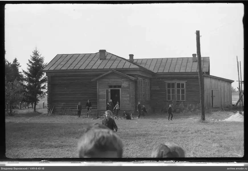 Children and teenagers near a wooden building